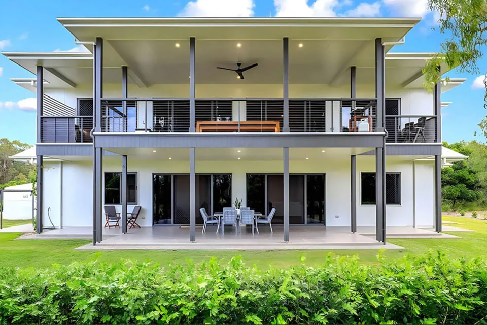 ellis-bg Two-storey home with wide covered decks and a hedge along the lawn